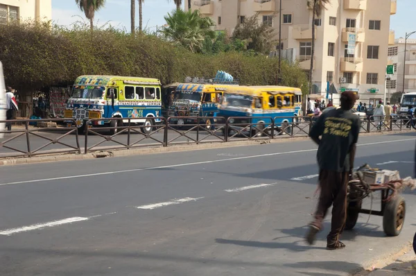 Road with buses and people in the city of Dakar. — ストック写真