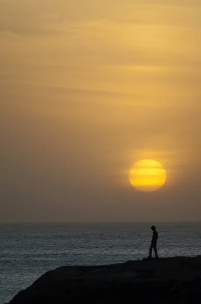 Человек на закате на побережье Дакара. — стоковое фото