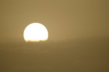 Sun through the clouds in a haze formed by airborne dust at dawn. Gran Canaria. Canary Islands. Spain.