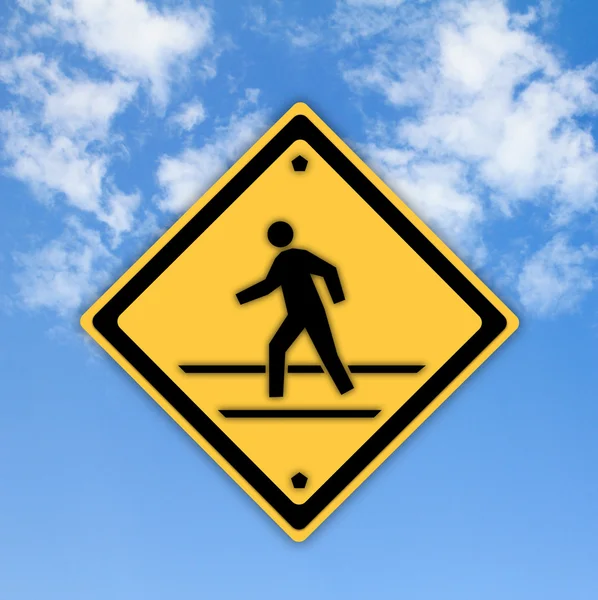 Crosswalk segno con un uomo che cammina sul giallo con un cielo blu indietro — Foto Stock