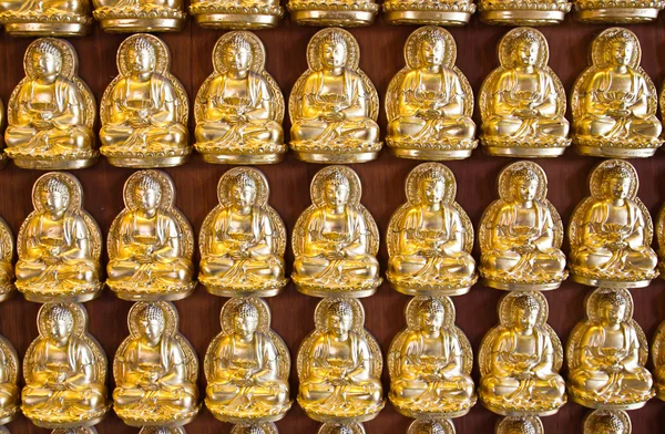 Muchos pequeña estatua de Buda en la pared en el templo chino, Tailandia —  Fotos de Stock