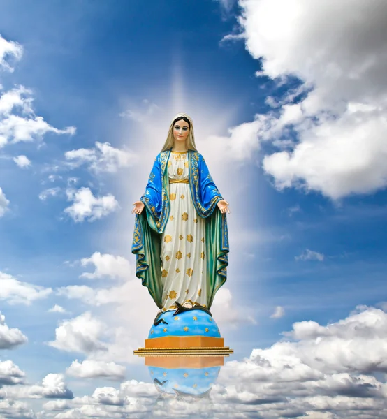 Standbeeld van de Maagd Maria in de hemelachtergrond. — Stockfoto