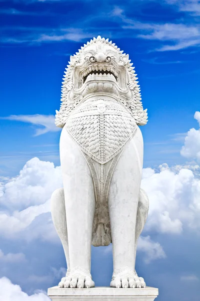 Sculpture antique lion gardien sur fond bleu ciel . — Photo