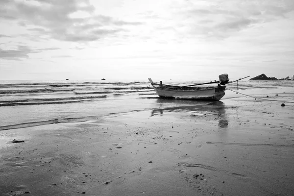 Un viejo barco pesquero aterrizando en la playa. Blanco y negro . — Foto de Stock