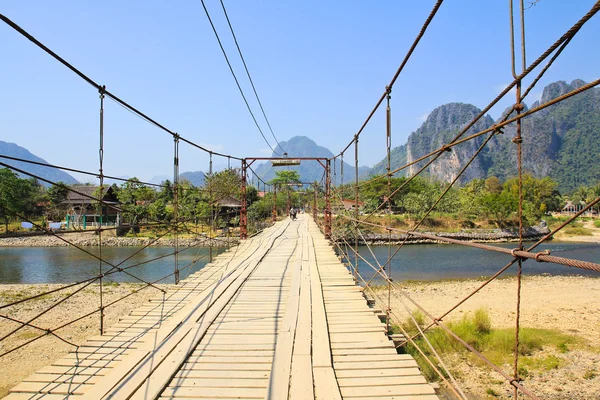 Most přes řeku song, vang vieng, laos. — Stock fotografie