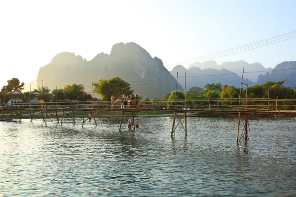 VANG VIENG, LAOS - FEB 1: Local people and tourists cross the ba — Stock Photo, Image