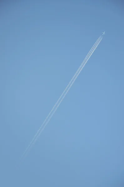 Closeup em contrail avião contra céu azul claro — Fotografia de Stock