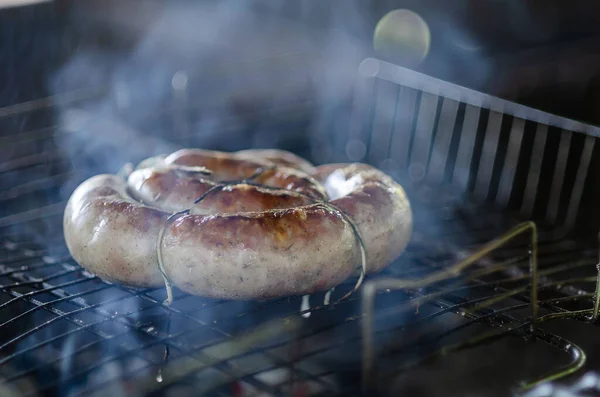 fried sausages on the grill with smoke evoke the emotion of a pleasant outdoor recreation, with delicious food taken from the top of the people in the photo no