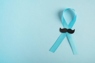 Açık mavi arka planda bıyıklı prostat kanseri farkındalığı. Tıp, erkek sağlığı konsepti. Üst görünüm, alanı kopyala