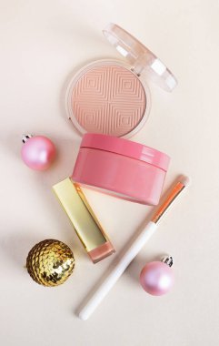 Pastel arka planda festival dekoru olan kozmetik ürünleri. Noel ve yeni yıl indirimi, hediyeler, güzellik ve cilt bakımı konsepti. Üst görünüm, düz görünüm, dikey