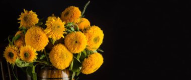 Siyah arkaplanda bir demet dekoratif ayçiçekli arkaplan afişi ve seçici odaklı kopya alanı