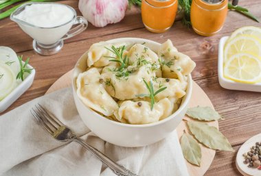 Koyu ahşap arka plandaki bir kasede farklı doldurulmuş hamur tatlısı.
