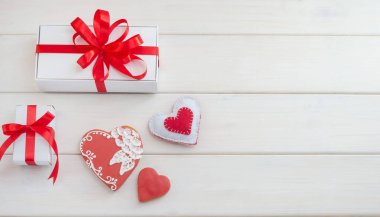 Arkaplanda zencefilli kurabiye, kalpler şeklinde hediyeler ve beyaz ahşap bir masada fotokopi alanı..