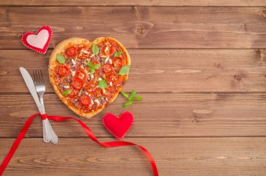 Sevgililer Günü arkaplanı koyu ahşap kaplamalı ve fotokopi alanı olan pizza kalbi..