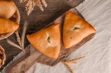 İştah açıcı taze hamur işi. Ahşap arka planda farklı dolguları olan turtalar.