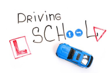 Ehliyet kursunda karatahta, Sürücü Okulu başlığı ile Eğitim ve Yaratıcı kompozisyon. Oyuncak araba modeli. Trafik işaretleri. Beyaz izole arkaplan, işaretler için tahta