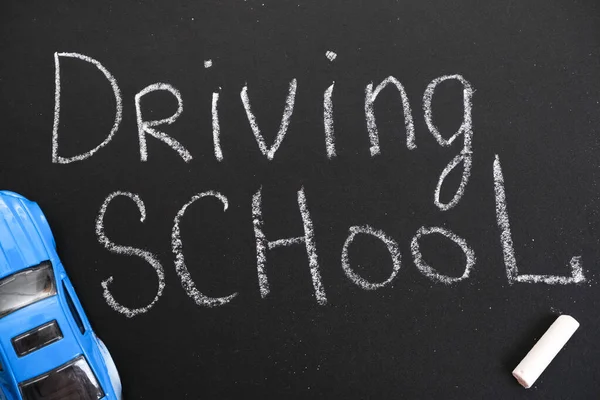 Ehliyet kursunda karatahta, Sürücü Okulu başlığı ile Eğitim ve Yaratıcı kompozisyon. Oyuncak araba modeli. trafik işaretleri