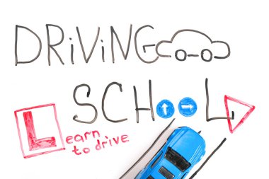 Ehliyet kursunda karatahta, Sürücü Okulu başlığı ile Eğitim ve Yaratıcı kompozisyon. Oyuncak araba modeli. Trafik işaretleri. Beyaz izole arkaplan, işaretler için tahta