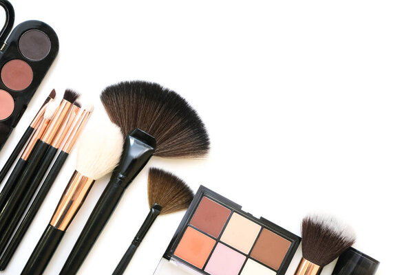 Decorative cosmetics and makeup brushes on a white isolated background, top view. place for your text, copyspace. the concept of applying makeup. visagiste