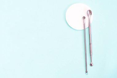 Yüzü temizlemek için uno kaşık yumuşak bir turkuaz arka planda. düz konum, kozmetoloji ve araçlar konsepti