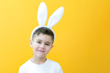 Sarı arka planda tavşan kulaklı neşeli çocuk. Komik, mutlu çocuk. metin ve düzen için boşluk kopyala.