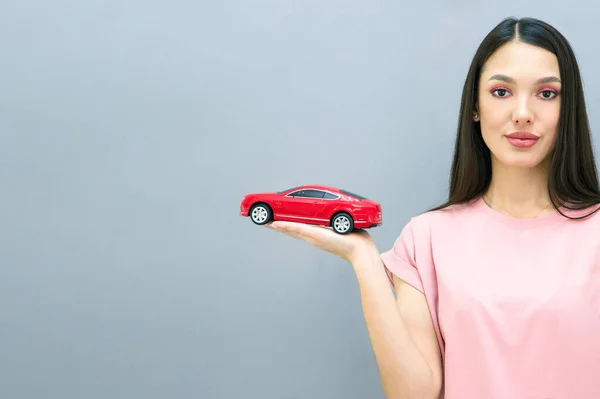 彼女の手に車を持った美しい笑顔の若い女性 ドライビングスクールで学び 新しい車を購入するという概念 灰色の背景で — ストック写真