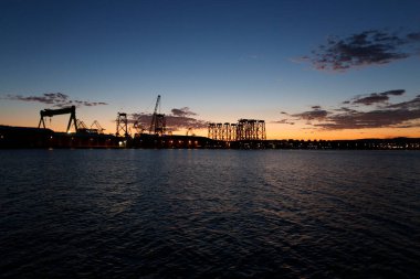 Ferrol, İspanya 'da günbatımının arka planında yer aldığı tersanelerde rüzgâr tarlaları için ceket yapımı