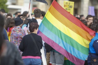 Coruna-İspanya. 28 Haziran 2022 'deki eşcinsel onur yürüyüşü sırasında bayrağı LGBT renkleriyle taşıyan gösterici.