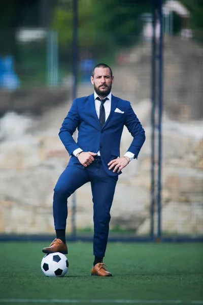 European Football Championship concept. business man posing with a ball on his foot inside a soccer field