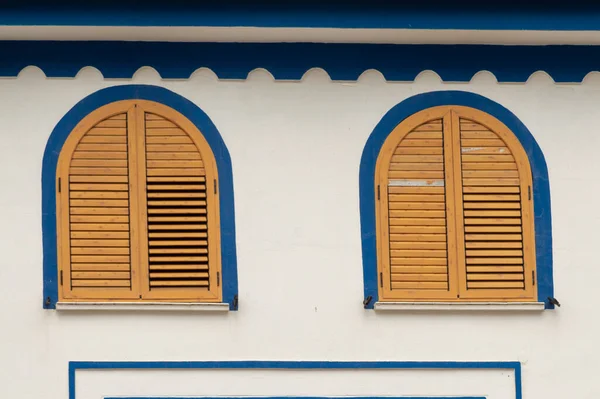 Yuvarlak kahverengi pencereli beyaz ve mavi cephe dekoru