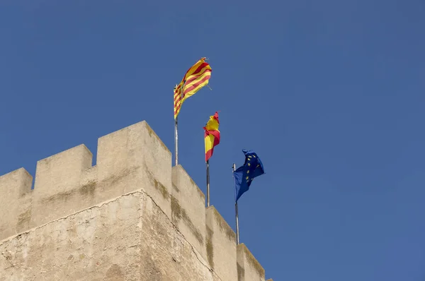 高くそびえる石塔の上に掲げられた旗は — ストック写真