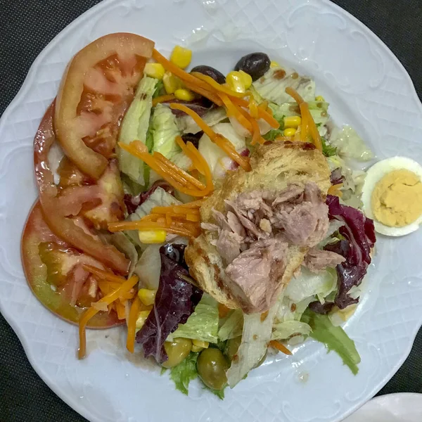 Yumurta, ton balığı, domates ve diğer malzemelerle marul salatası.
