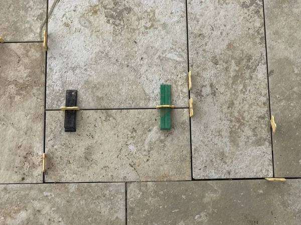 installation of tiles on the floor separated by plastic spacers