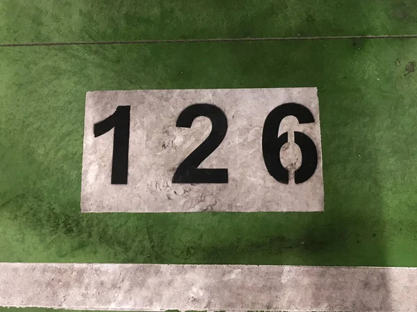 Número Pintado Branco Sobre Fundo Verde Chão Uma Garagem Estacionamento — Fotografia de Stock