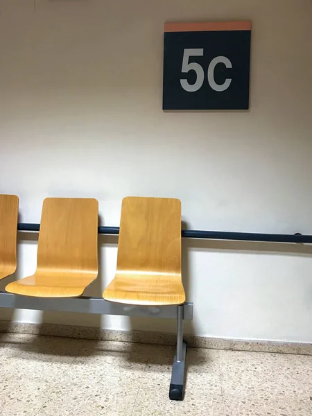 Hastanenin beşinci katındaki bekleme odasında tahta koltuklar.