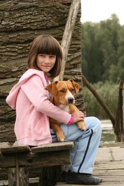 Menina segurando um cão — Fotografia de Stock