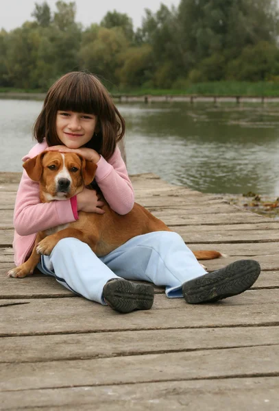 Flicka som håller en hund — Stockfoto