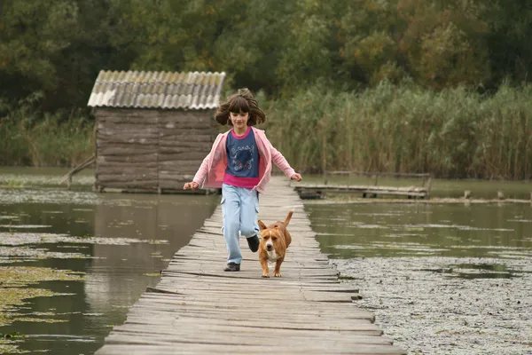 Mädchen und Hund rennen — Stockfoto