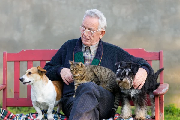 Oude man met zijn huisdieren — Stockfoto