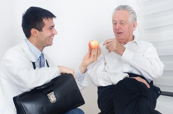 Medico mostrando mela al paziente — Foto Stock