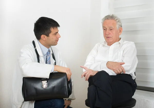 Uomo anziano con giovane medico — Foto Stock