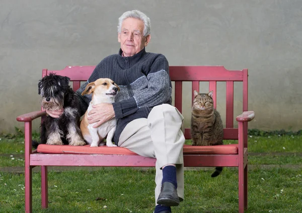 Homem idoso com animais de estimação — Fotografia de Stock