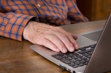 Yaşlı adam dizüstü bilgisayar kullanıyor