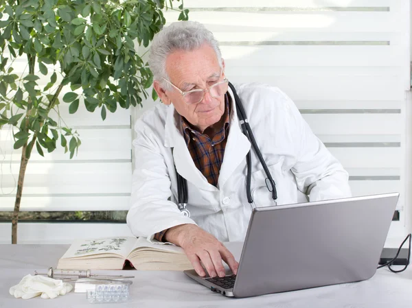 Médico sênior com laptop — Fotografia de Stock