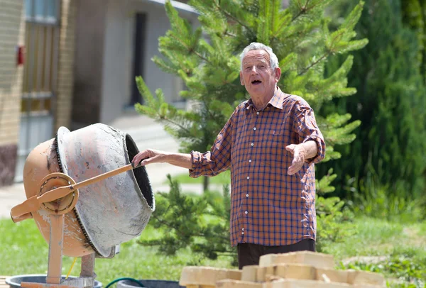 Oude man met beton mixer — Stockfoto