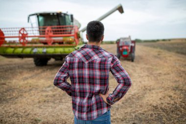 Hasat edilen soya tarlasında dikiz aynasından hasat makinesiyle traktörün birleşimine bakıyoruz.