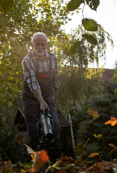 Senior Man Som Arbetar Trädgården Med Lövblåsare Hösten Säsongsarbete Utomhus — Stockfoto