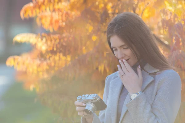 秋の時間に公園で古いアナログカメラで写真を撮る赤毛の女の子の肖像画 — ストック写真