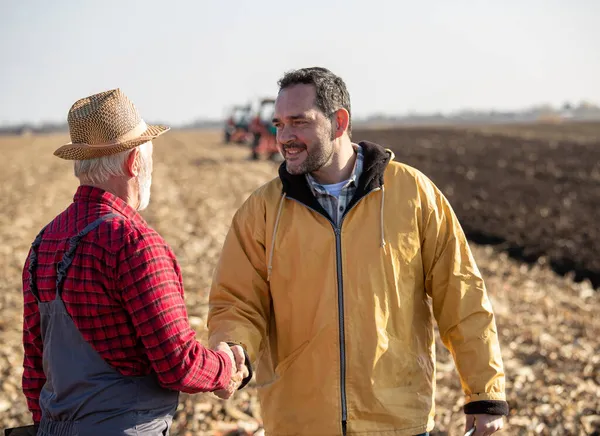 Due Agricoltori Che Stringono Mano Sul Campo Autunno Mentre Trattori — Foto Stock