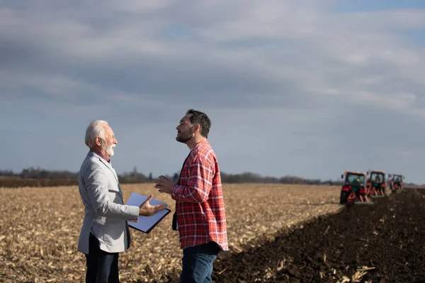 Experienced Business Man Talking Younger Farmer Field Front Tractors Autumn — Stock Photo, Image